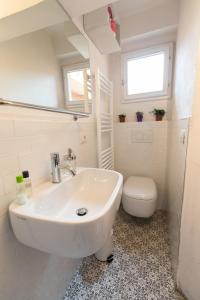 een witte badkamer met een wastafel en een toilet bij HouSmart Pratello 48 in Bologna +28 foto's