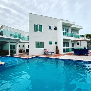 uma casa grande com uma piscina em frente em Terraço Hotel em Lagoinha