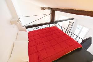 een slaapkamer met een rode deken op een trap bij HouSmart Pratello 48 in Bologna