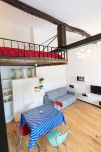 een woonkamer met een tafel en een hoogslaper bij HouSmart Pratello 48 in Bologna