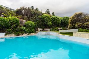 a large pool of blue water in a yard at Bayview 203 in Hermanus