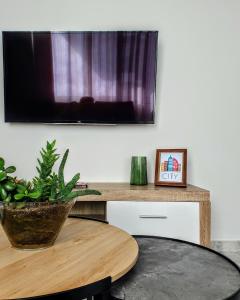 ein Wohnzimmer mit einem Tisch und einem Flachbild-TV in der Unterkunft City House Elegant in Kalamata