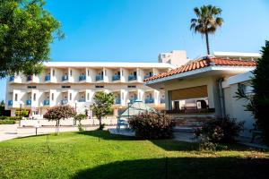 un edificio con una palmera delante de él en Kissos Hotel, en Pafos