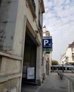 a building with a parking sign on the side of it at Hotel Du Cygne Tours in Tours
