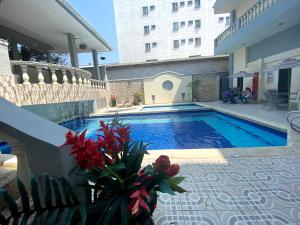 a swimming pool with flowers on the side of a building at Hotel Puerta de Oro in Barranquilla +35 photos