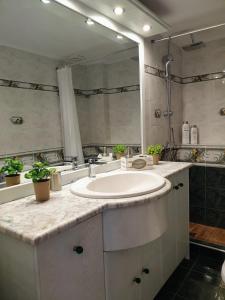 ein Badezimmer mit einem Waschbecken und einem großen Spiegel in der Unterkunft City House Elegant in Kalamata