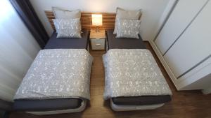 2 łóżka pojedyncze w małym pokoju z lampką w obiekcie Apartamento ÁTICO SOL Los Miradores del Puerto w mieście La Manga del Mar Menor