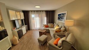 sala de estar con sofá, sillas y TV en Apartamento ÁTICO SOL Los Miradores del Puerto, en La Manga del Mar Menor