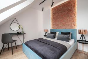sypialnia z niebieskim łóżkiem i ceglaną ścianą w obiekcie Absyntapart - Bulwar Staromiejski we Wrocławiu