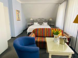 a hotel room with a bed and a blue chair at Apartment Barbara in Mariánské Lázně