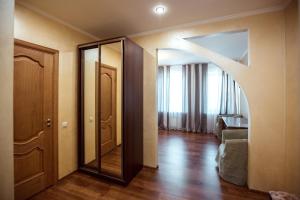 ein Zimmer mit einem Spiegel und ein Wohnzimmer mit einem Sofa in der Unterkunft Chaika Hotel in Kimry