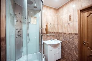 ein Bad mit einer Dusche und einem Waschbecken in der Unterkunft Chaika Hotel in Kimry