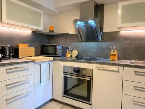 a kitchen with white cabinets and a microwave at Alice Apartment Wackernheim in Ingelheim am Rhein