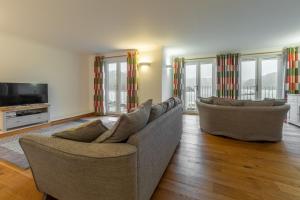 a living room with two couches and a television at Waterfront House in Saint Clement