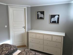 ein Schlafzimmer mit einer weißen Kommode und einer weißen Tür in der Unterkunft Notodden Sentrum Apartment NO 3 in Notodden