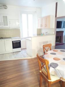 uma cozinha com uma mesa e uma cozinha com armários brancos em Appartement 2 chambres 52 m2 centre ville em Vendôme