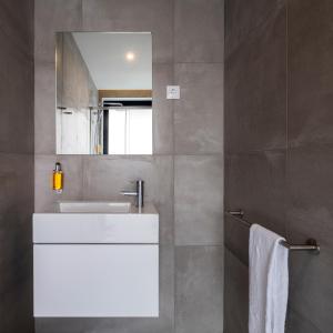 a bathroom with a white sink and a mirror at Aqua - Pópulo Eco Village in Ponta Delgada