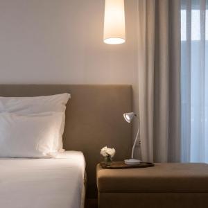 a bedroom with a bed and a lamp on a table at Aqua - Pópulo Eco Village in Ponta Delgada