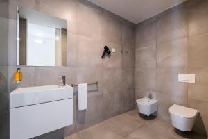 a bathroom with a white sink and a toilet at Aqua - Pópulo Eco Village in Ponta Delgada