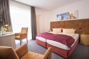 a hotel room with a large bed and a chair at Hotel Residenz in Ravensburg