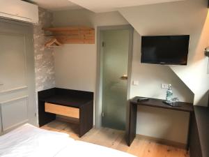 1 dormitorio con 1 cama y TV en la pared en Jauch's Löwen Hotel-Restaurant en Neuershausen