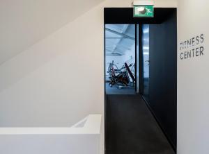 a hallway with a fitness center with a bike in a room at Aqua - Pópulo Eco Village in Ponta Delgada