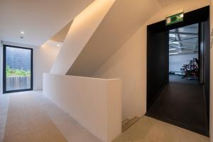 an open stairwell in a house with a white wall at Aqua - Pópulo Eco Village in Ponta Delgada