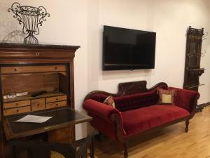 a living room with a red couch and a tv at Avalon Bed & Breakfast Themen/- Nichtraucherhotel in Hannover