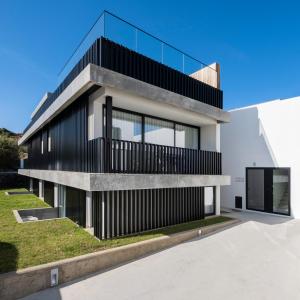 a house with a black and white facade at Aqua - Pópulo Eco Village in Ponta Delgada