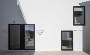 two glass doors with a sign on the side of a building at Aqua - Pópulo Eco Village in Ponta Delgada