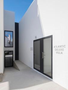an entrance to an art gallery with two glass doors at Aqua - Pópulo Eco Village in Ponta Delgada