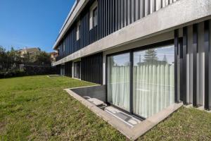 a building with large windows on the side of it at Aqua - Pópulo Eco Village in Ponta Delgada