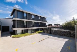 a black building with a parking lot in front of it at Aqua - Pópulo Eco Village in Ponta Delgada