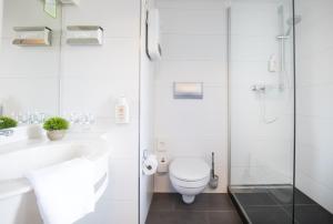 a bathroom with a toilet and a sink and a shower at Hotel Residenz in Ravensburg +54 photos