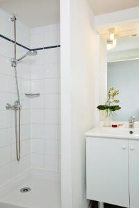 a white bathroom with a shower and a sink at Séjours & Affaires Nantes La Beaujoire in Nantes +6 photos