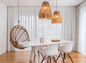 a dining room with a white table and chairs at Aqua - Pópulo Eco Village in Ponta Delgada