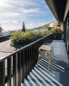 a balcony with two chairs and a table on it at Aqua - Pópulo Eco Village in Ponta Delgada