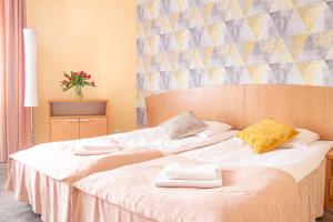 2 Betten in einem Hotelzimmer mit Handtüchern darauf in der Unterkunft AL-DOM apartamenty Olymp Sunshine in Kołobrzeg