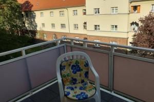 einen Stuhl auf einem Balkon mit Blick auf ein Gebäude in der Unterkunft Nice Appartement near TradeFair and City 8 Min. in Köln