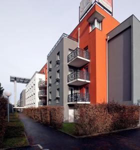 an orange building with balconies on a street at Séjours & Affaires Nantes La Beaujoire in Nantes