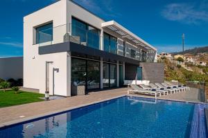 una casa con piscina frente a ella en OurMadeira - Seacrest, premium luxury, en Ponta do Sol