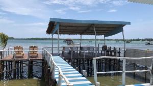 un quai avec des chaises et des tables sur l'eau dans l'établissement Blue Coral Homestay, à Karimunjawa