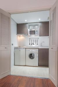 eine Küche mit Waschmaschine und Mikrowelle in der Unterkunft Tu Escapada Urbana - Plaza de Castilla III, Diseño y Localización in Madrid
