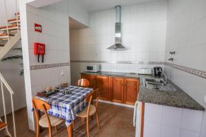 a small kitchen with a table and a sink at Casa Algarvia in Lagos
