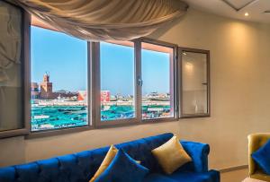 BnB MEDINA في مراكش: غرفة معيشة مع أريكة زرقاء ونوافذ