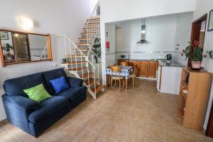 a living room with a blue couch and a kitchen at Casa Algarvia in Lagos