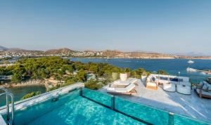 a swimming pool with a view of the water at Four Seasons Astir Palace Hotel Athens in Athens