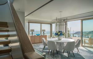 a dining room with a table and chairs and a staircase at Four Seasons Astir Palace Hotel Athens in Athens