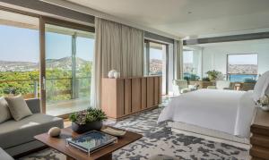 a bedroom with a large bed and a living room at Four Seasons Astir Palace Hotel Athens in Athens