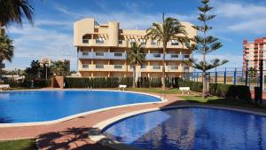 duży basen przed budynkiem w obiekcie Apartamento ÁTICO SOL Los Miradores del Puerto w mieście La Manga del Mar Menor